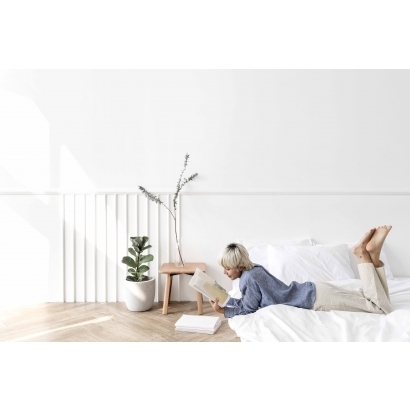 blond-haired-asian-woman-reading-book-mattress-floor.jpg